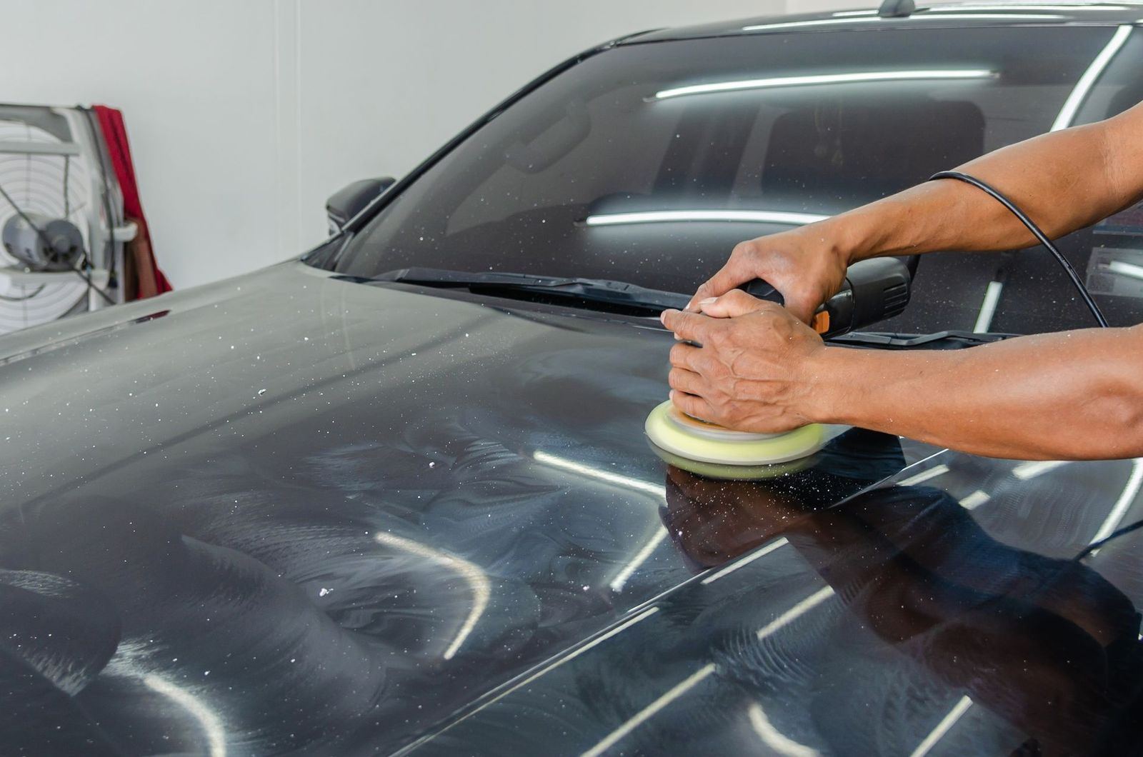 Correction de peinture au polisseur sur une carrosserie noire — studio CANDELA